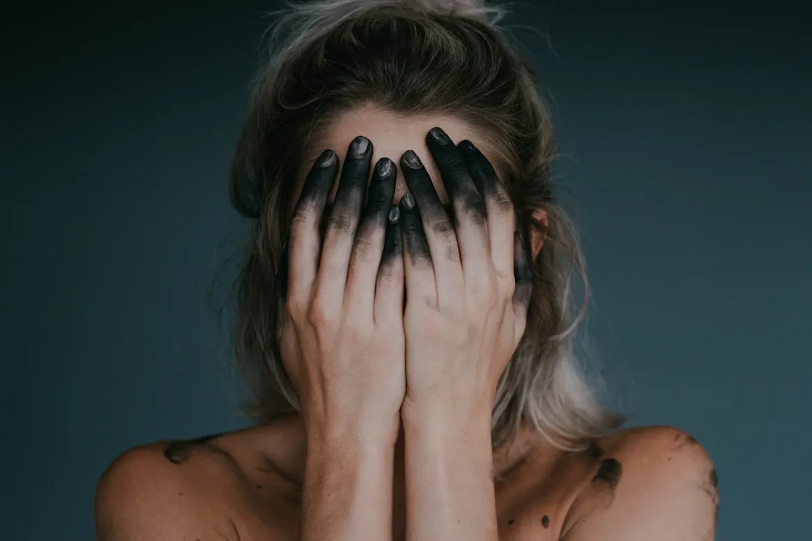 woman covering face feeling guilty